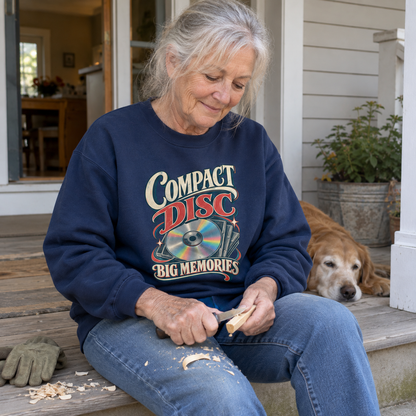 Senior woman carves wood on porch wearing navy vintage sweatshirt printed Compact Disc Big Memories.