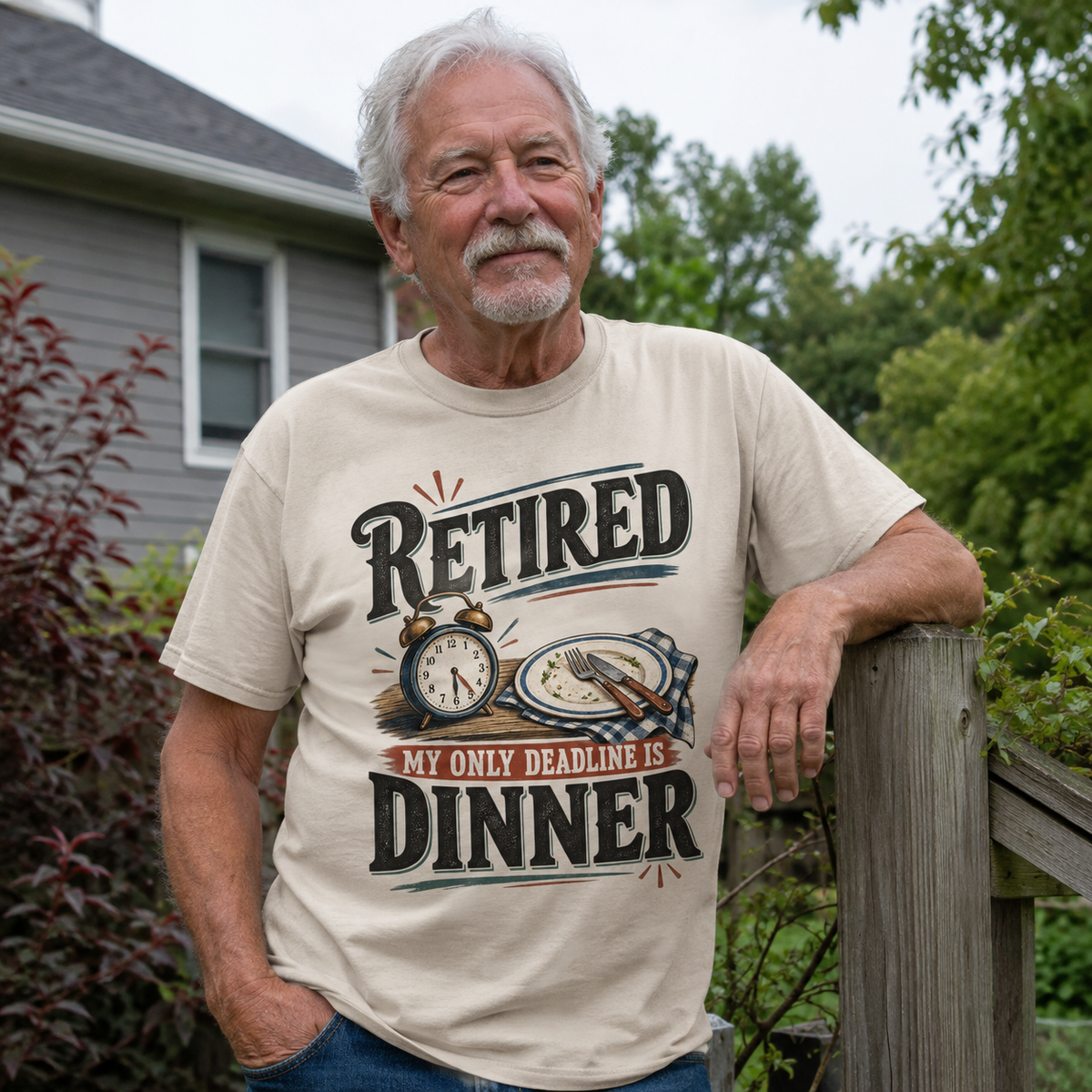 Senior man wearing cream vintage t-shirt with printed My Only Deadline Is Dinner slogan outdoors