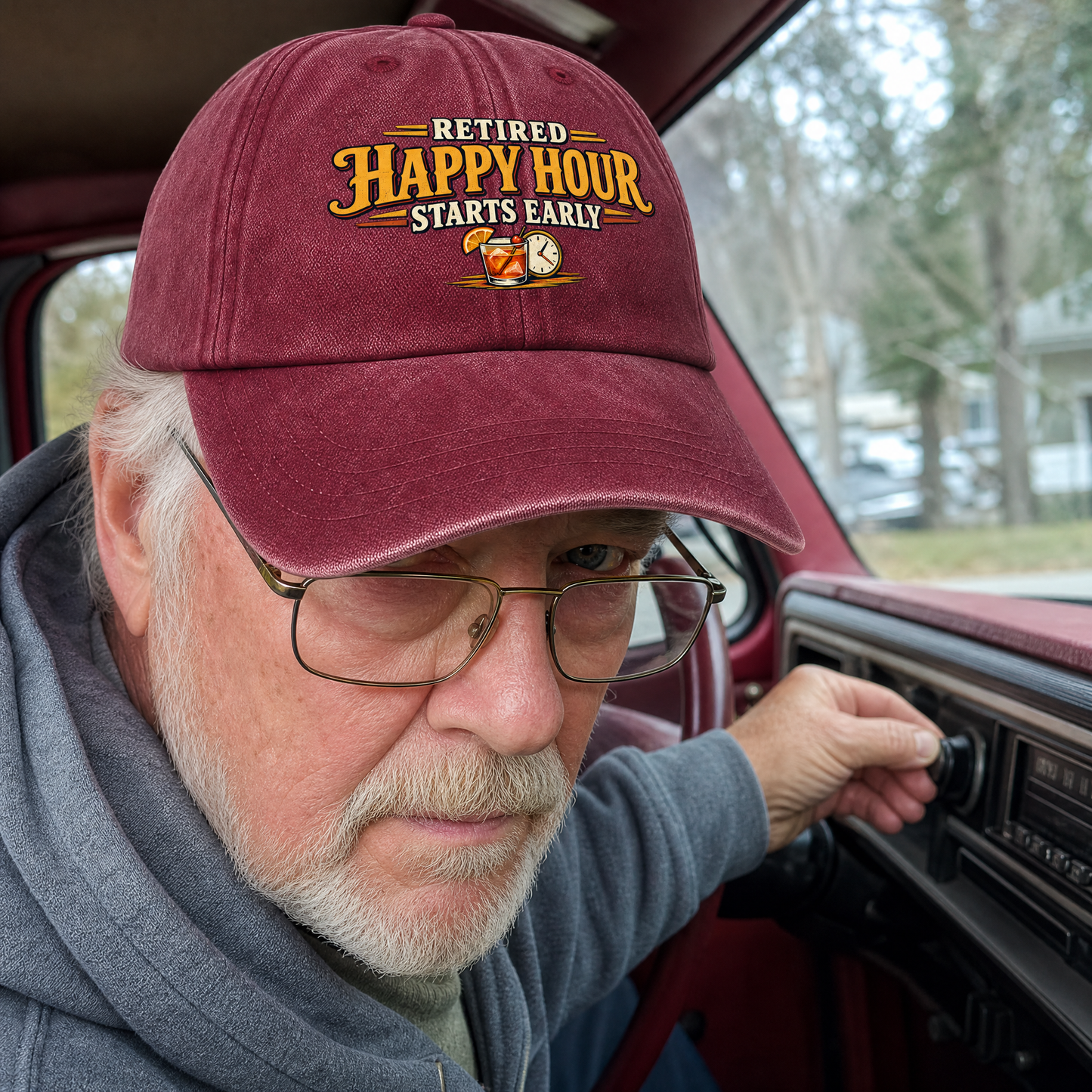 Burgundy vintage washed cap with printed Retired Happy Hour Starts Early slogan on senior man in car