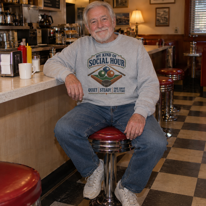 Senior man wearing gray vintage sweatshirt with printed social hour billiards design in diner setting