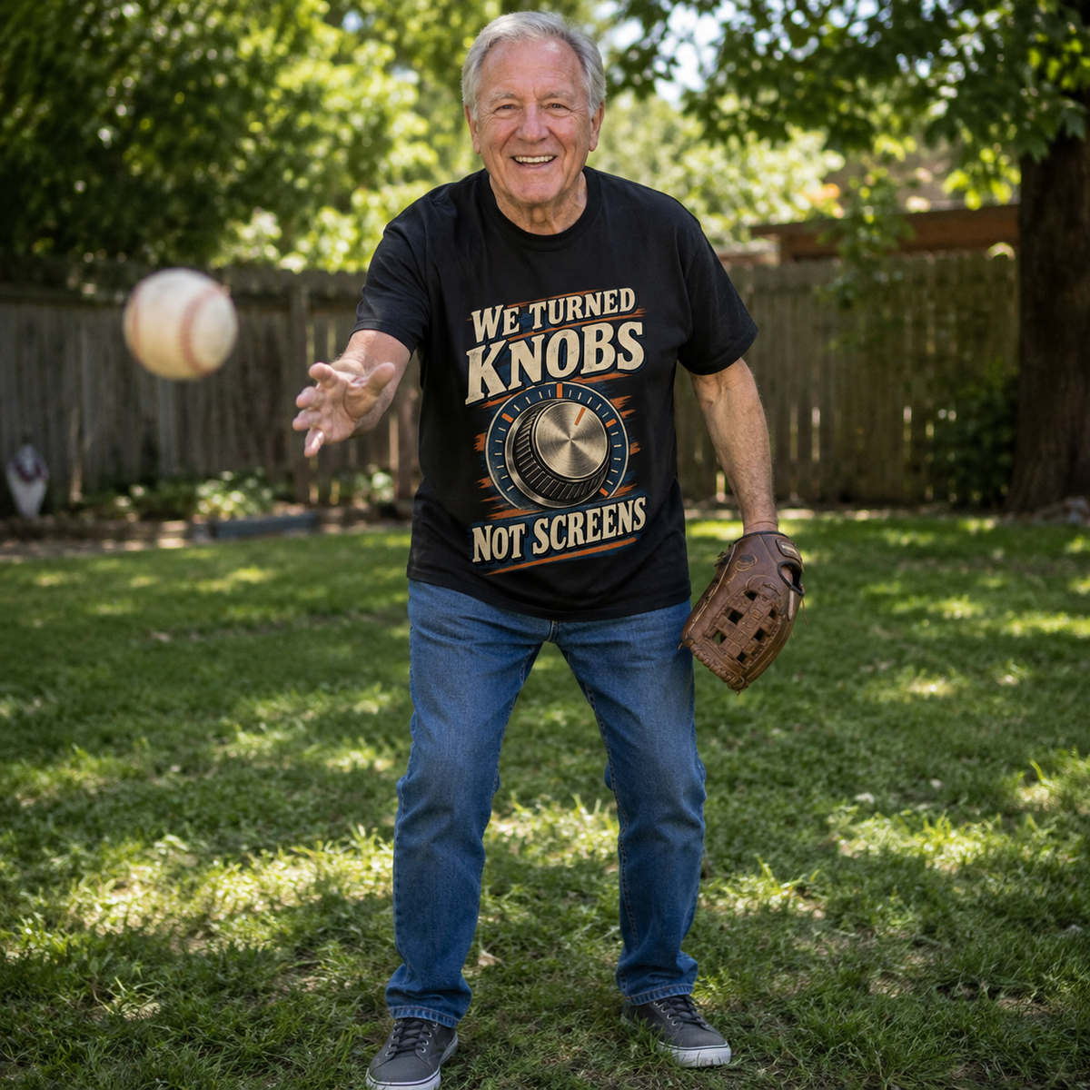 Senior man wearing black vintage t-shirt with printed We Turned Knobs Not Screens slogan outdoors