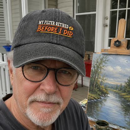 Vintage washed cap printed “My Filter Retired Before I Did,” worn by senior man outdoors.