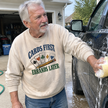 Beige vintage sweatshirt with “Cards First. Errands Later” printed design worn by senior man washing car