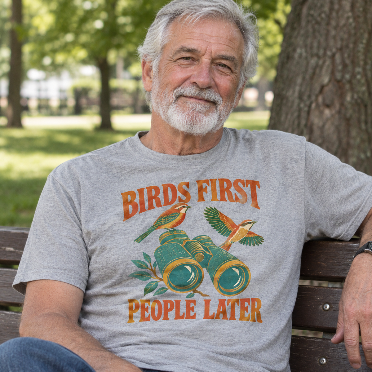 Gray vintage t-shirt with printed Birds First People Later design, worn by senior man outdoors.