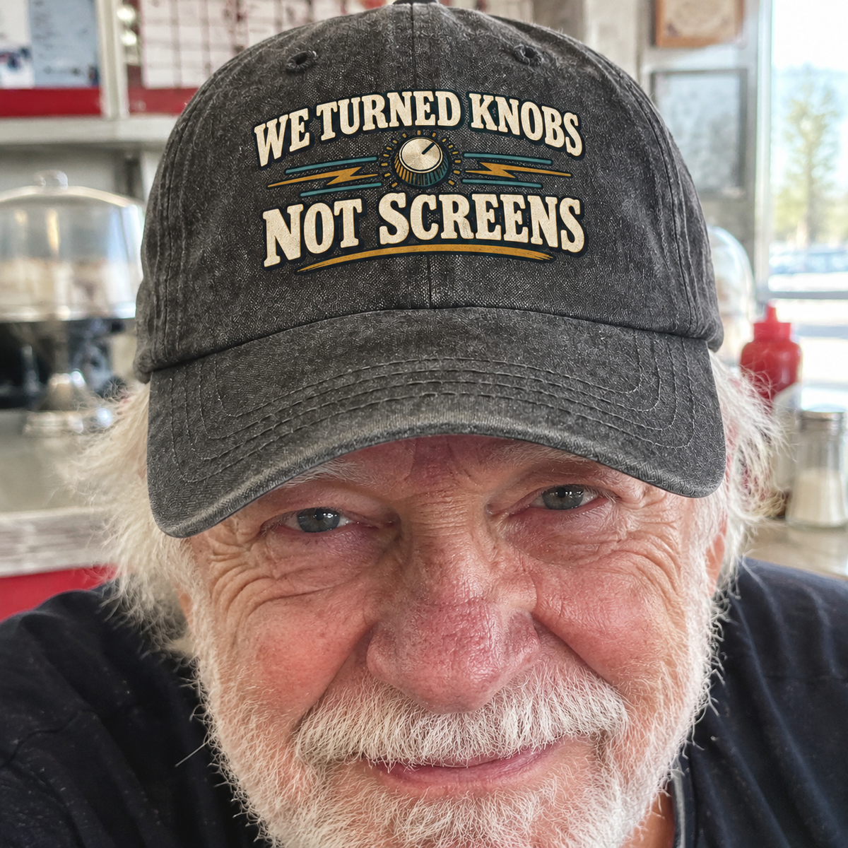 Senior man wearing black vintage washed cap with printed We Turned Knobs Not Screens design