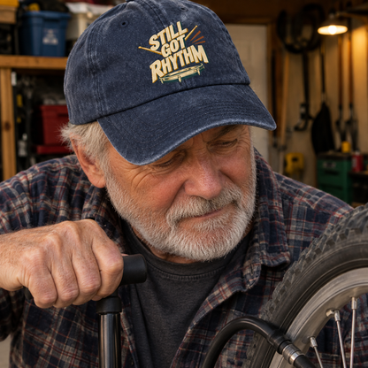 Senior man wearing blue vintage washed cap with printed Still Got Rhythm slogan in workshop
