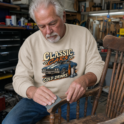 Senior man wearing beige vintage sweatshirt with printed Classic Cars Cold Drinks design in workshop