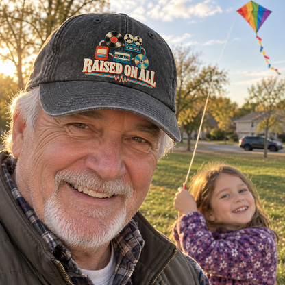 Senior man wearing black vintage washed cap with printed Raised On All design outdoors