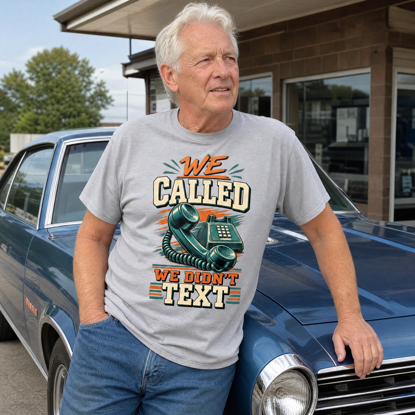 Senior man wearing vintage t-shirt with “We Called. We Didn’t Text” printed, beside classic car.