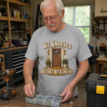 Senior man wearing gray vintage t-shirt with We Knocked Before We Came In print in workshop setting