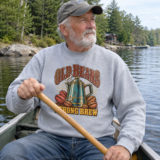 Senior man wearing gray vintage sweatshirt with printed Old Beans Strong Brew design in canoe
