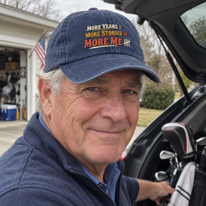 Senior man wears navy vintage washed cap printed More Years More Stories More Me outdoors.