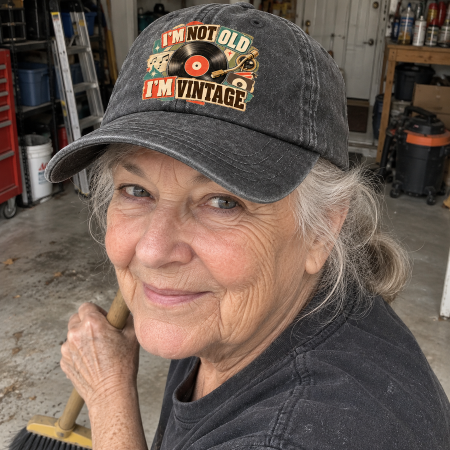 Senior woman in garage wearing charcoal vintage washed cap printed I'm Not Old. I'm Vintage