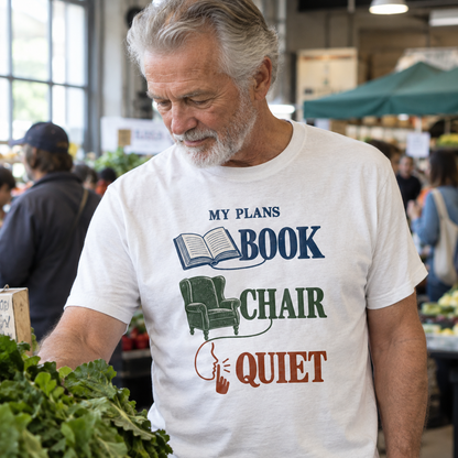 White vintage t-shirt with printed My Plans Book Chair Quiet slogan worn by senior man at market
