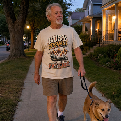 Cream vintage t-shirt with “Busy Signals Built Patience” print, worn by senior man walking dog.