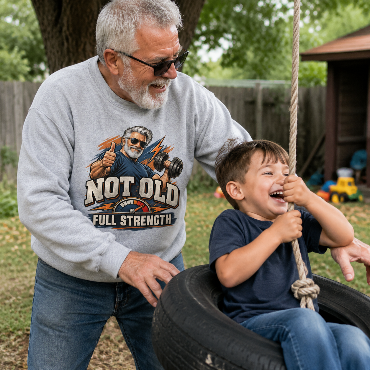Gray vintage sweatshirt with printed Not Old. Full Strength slogan, senior man outdoors with child