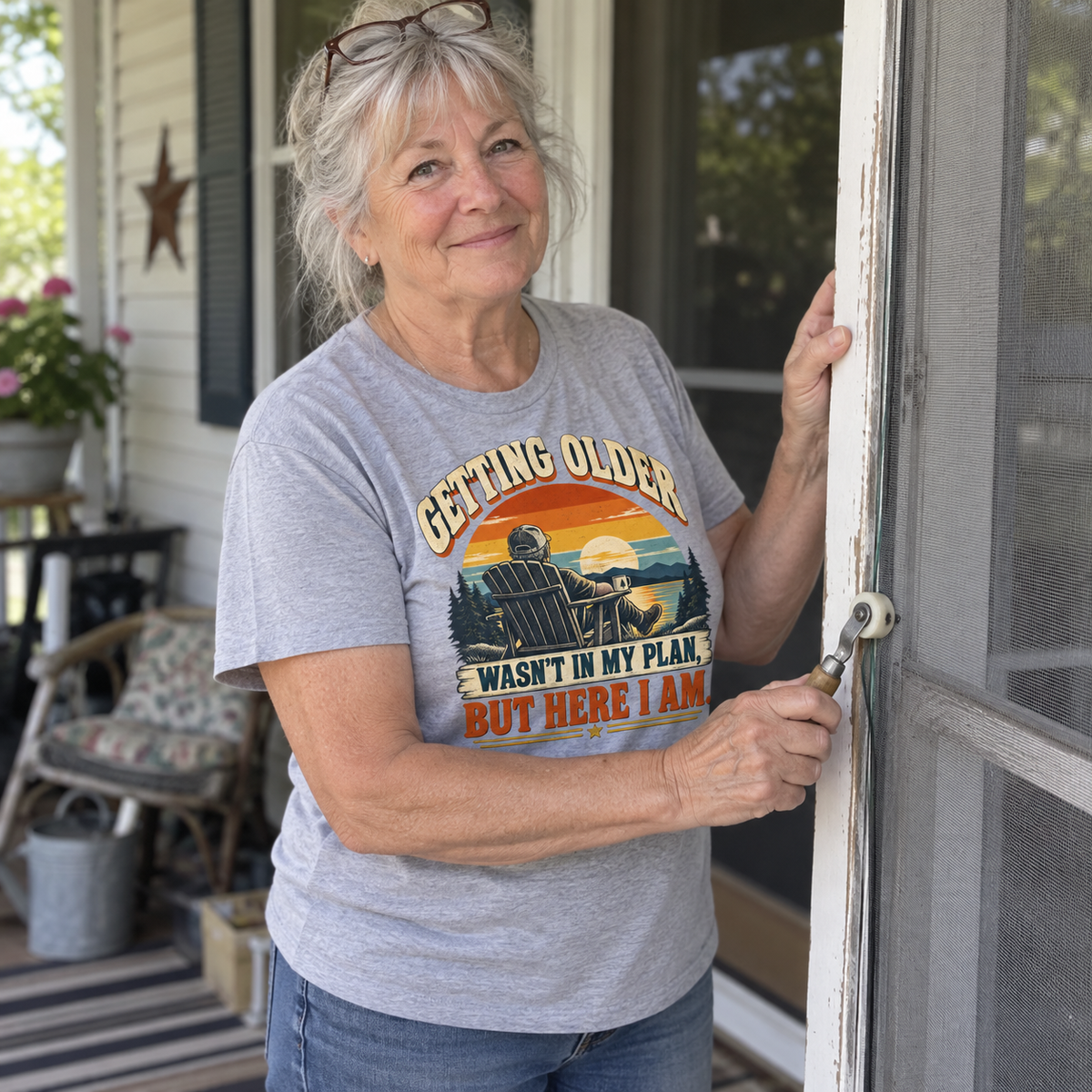 Senior woman on porch wearing gray vintage t-shirt with printed sunset and Getting Older slogan.