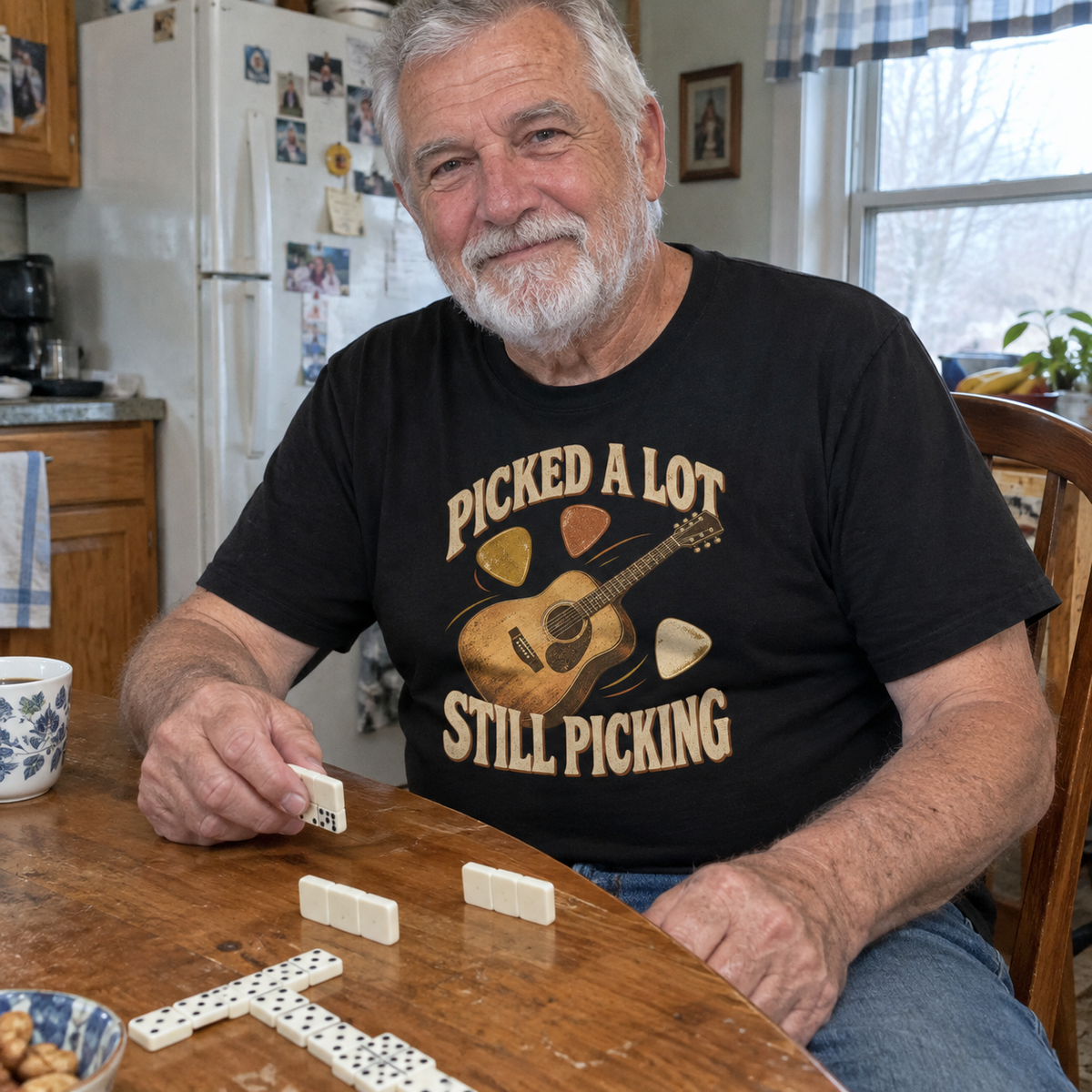 Vintage t-shirt with printed Picked A Lot Still Picking, worn by senior man playing dominoes.