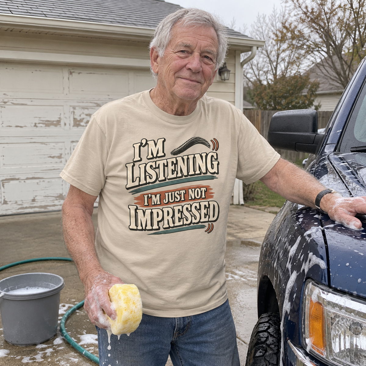 Senior man washing truck wears cream vintage t-shirt printed I'm Listening I'm Just Not Impressed