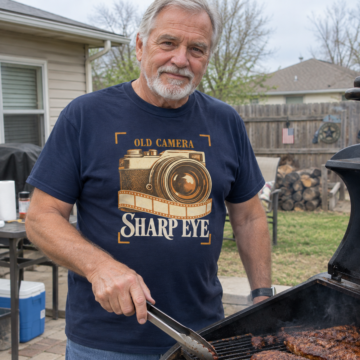 Navy vintage t-shirt with printed Old Camera Sharp Eye design worn by senior man grilling outdoors