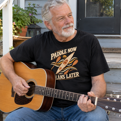 Black vintage t-shirt with Paddle Now Plans Later print worn by senior man playing guitar