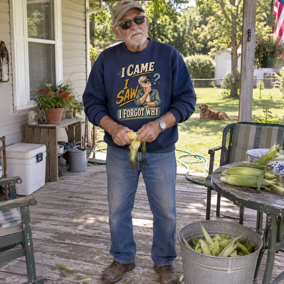 Senior man husking corn on porch in navy vintage sweatshirt with printed forgetful slogan