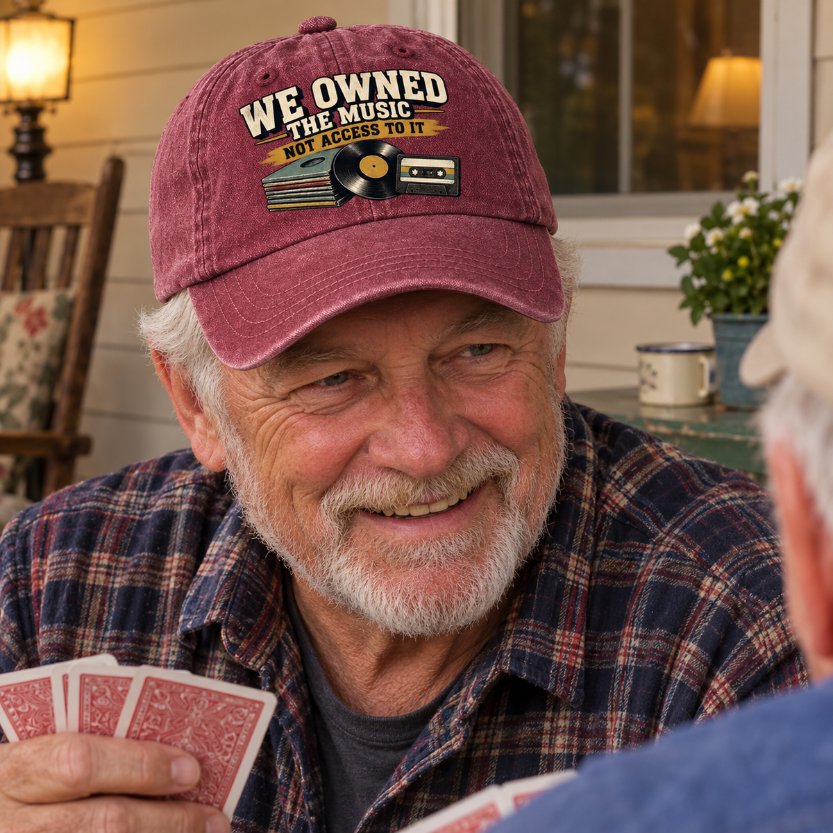 Vintage washed cap with printed music slogan worn by senior man playing cards indoors
