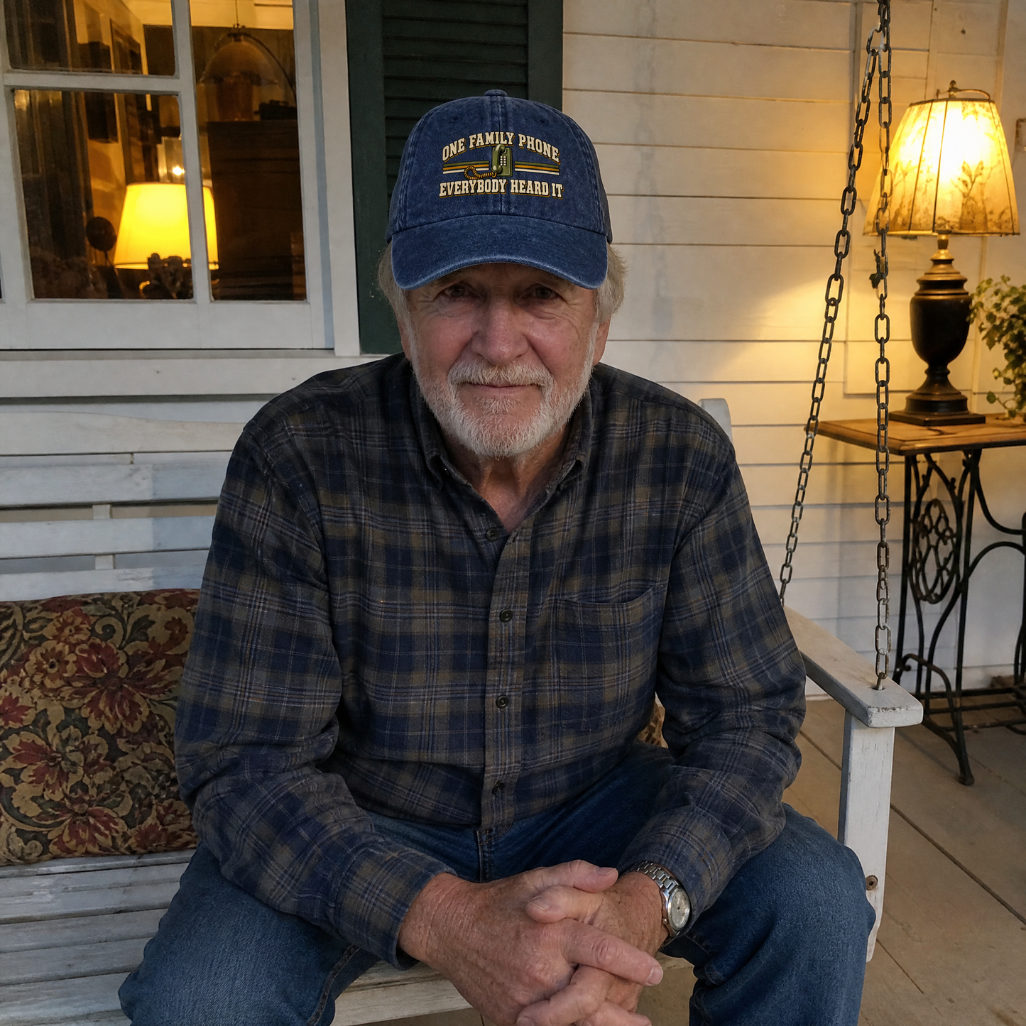 Senior man wearing blue vintage washed cap with printed family phone slogan, porch lifestyle.