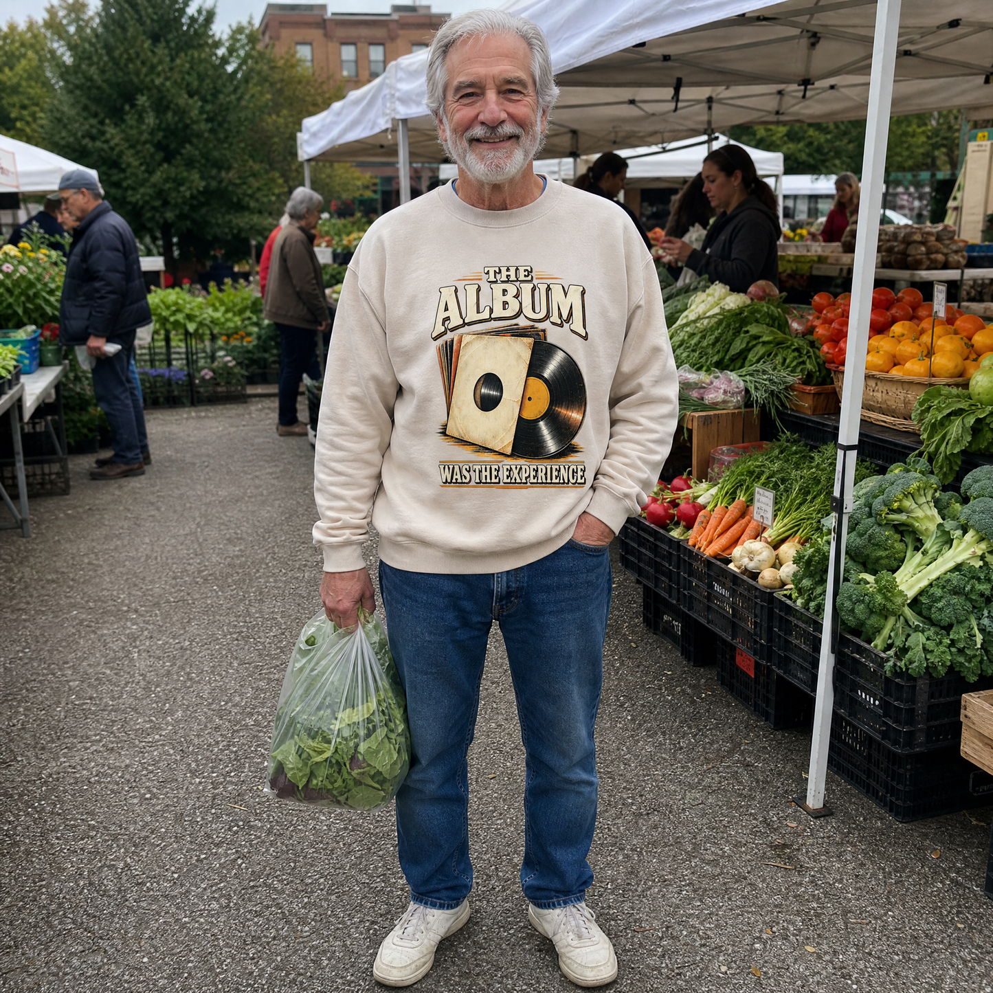Senior man wearing a cream vintage sweatshirt with The Album Was The Experience print at market.