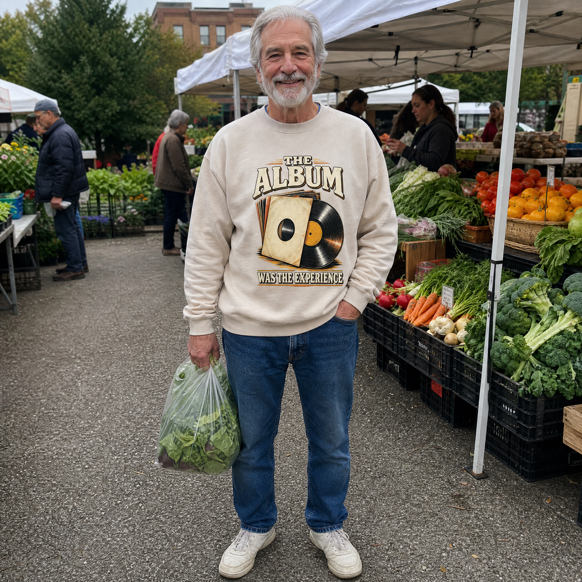 Senior man wearing a cream vintage sweatshirt with The Album Was The Experience print at market.