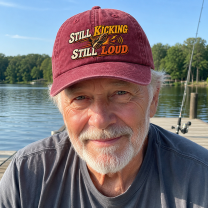 Senior man wearing red vintage washed cap with printed Still Kicking Still Loud slogan