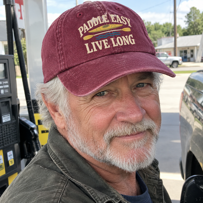 Senior man wearing maroon vintage washed cap with Paddle Easy Live Long printed design