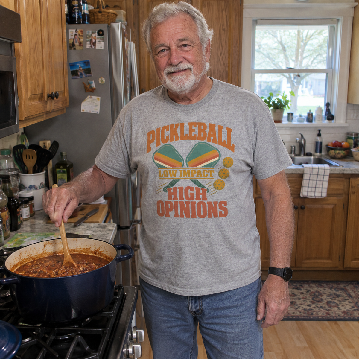 t-shirt with printed pickleball slogan while cooking in kitchen.