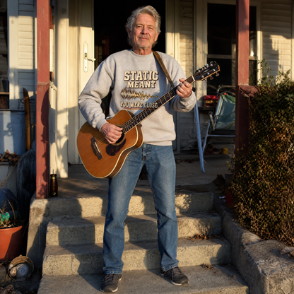 Vintage sweatshirt with printed “Static Meant You Were Close,” worn by senior man playing guitar.