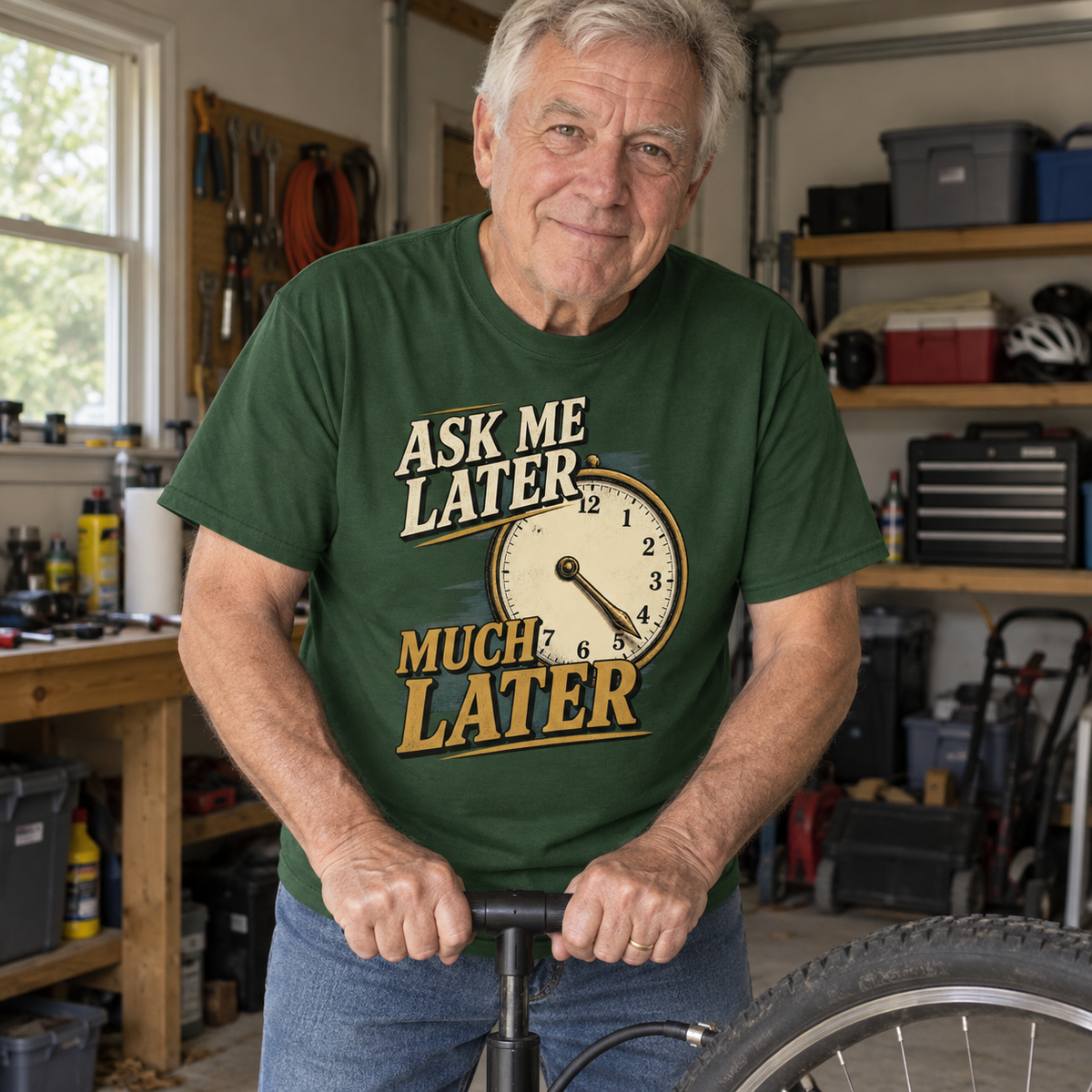 Senior man in garage wears green vintage t-shirt printed Ask Me Later Much Later.