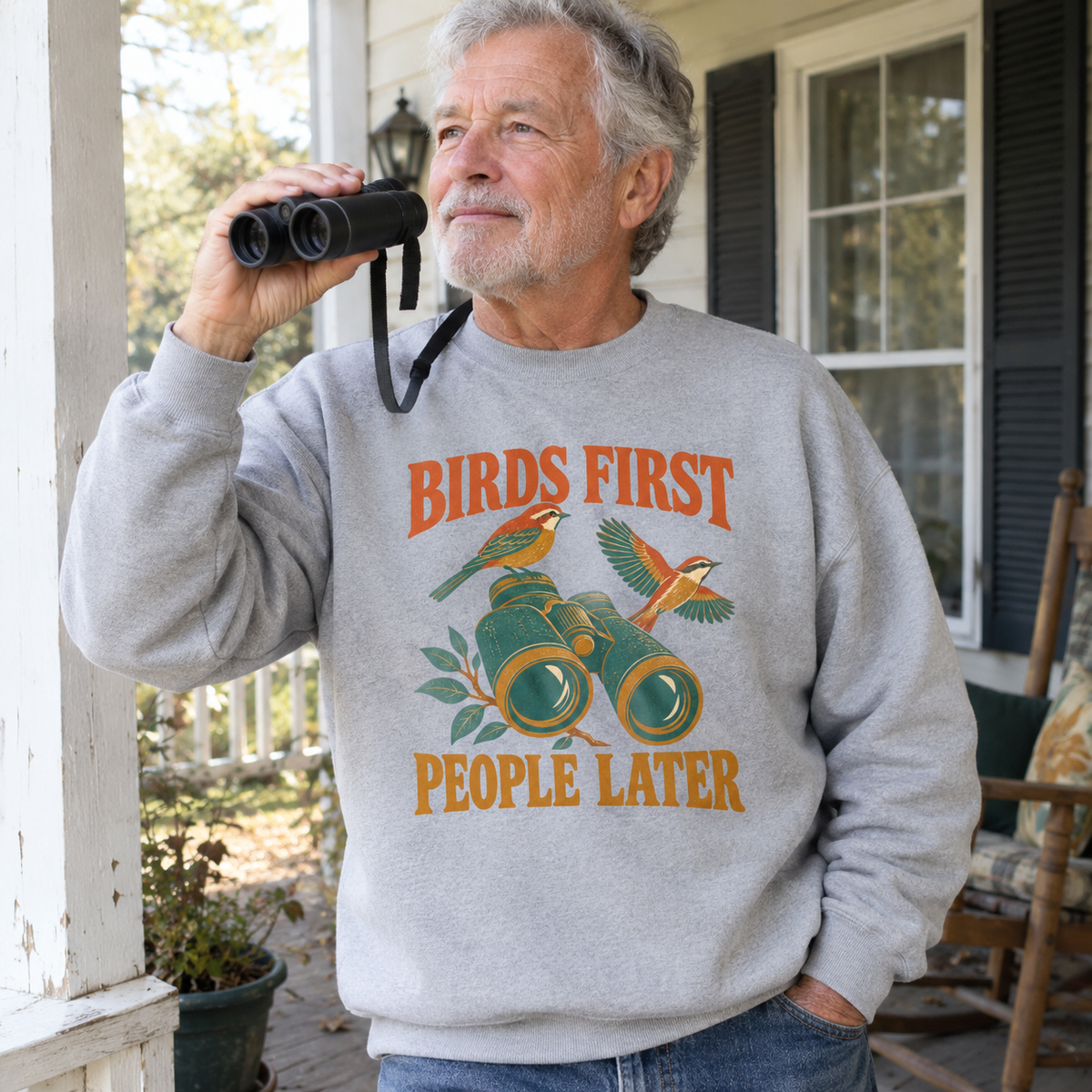 Gray vintage sweatshirt with printed Birds First People Later design worn by senior man outdoors.