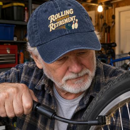 Senior man wearing a navy vintage washed cap with Rolling Through Retirement bowling design in garage