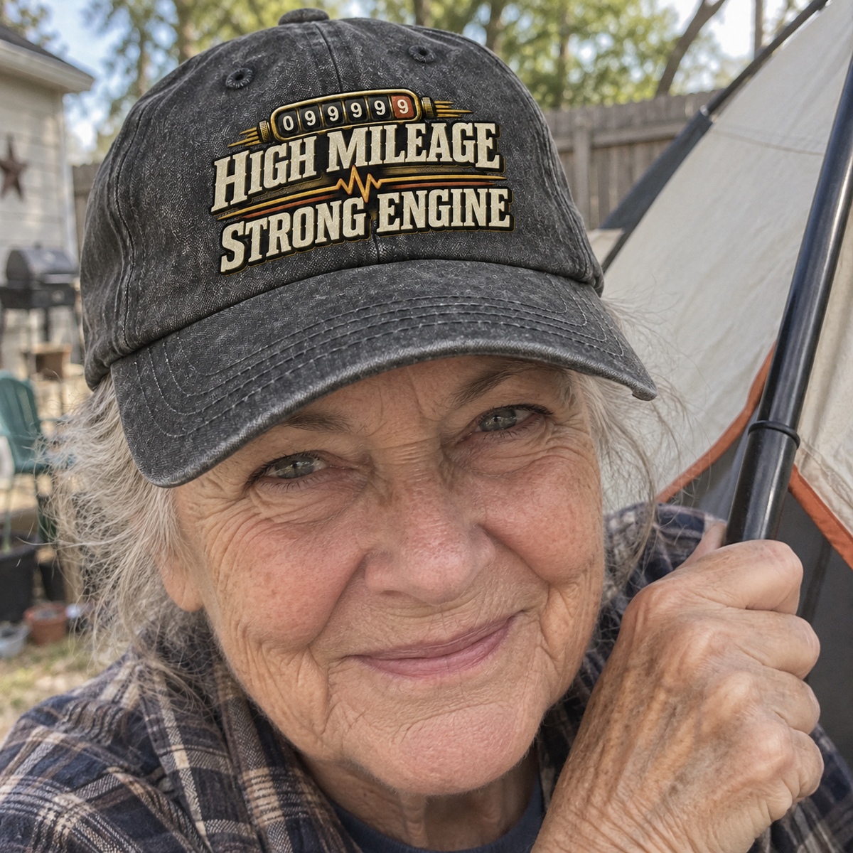 Senior woman outdoors wearing charcoal vintage washed cap with printed High Mileage Strong Engine slogan