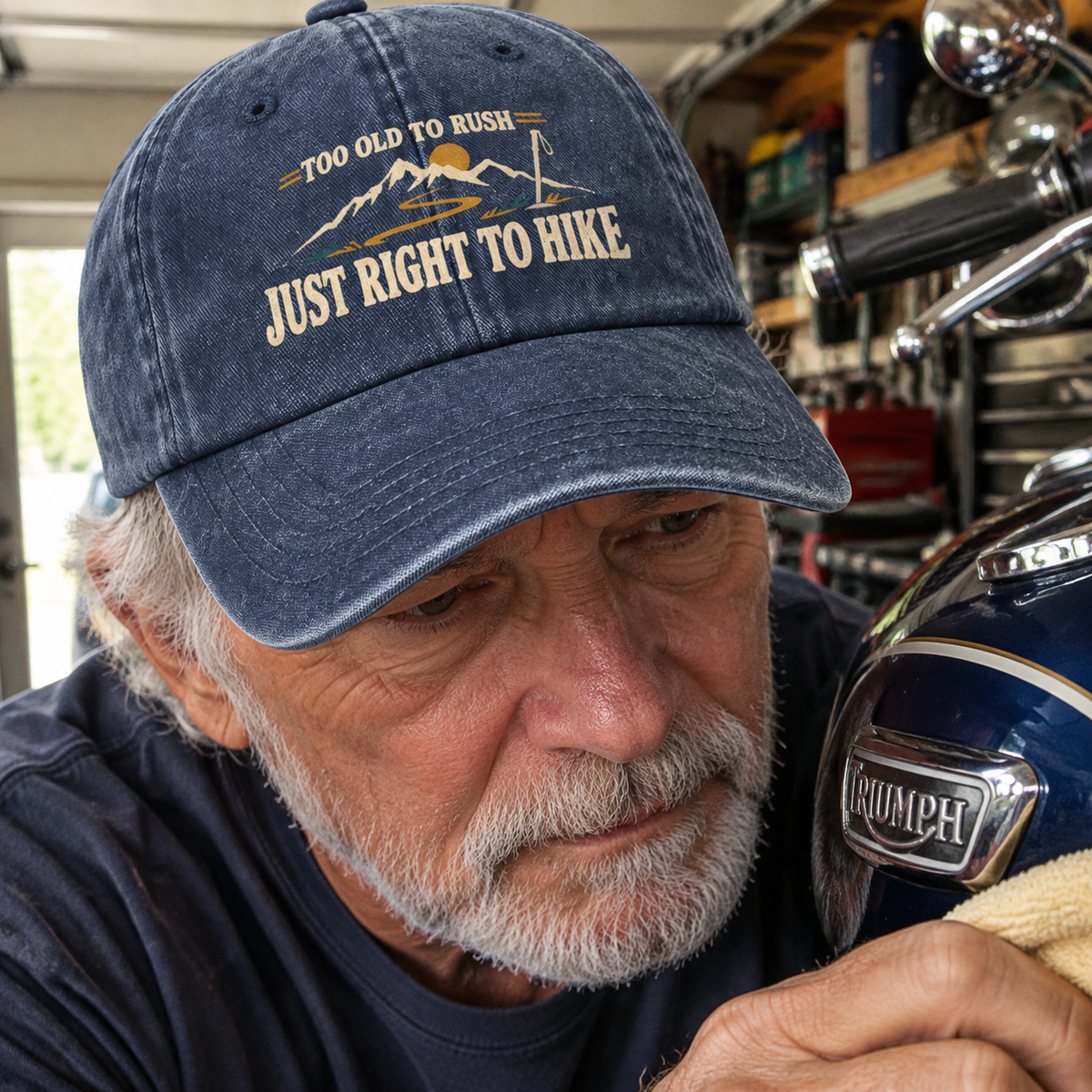 Navy vintage washed cap with printed hiking slogan worn by senior man in garage close-up