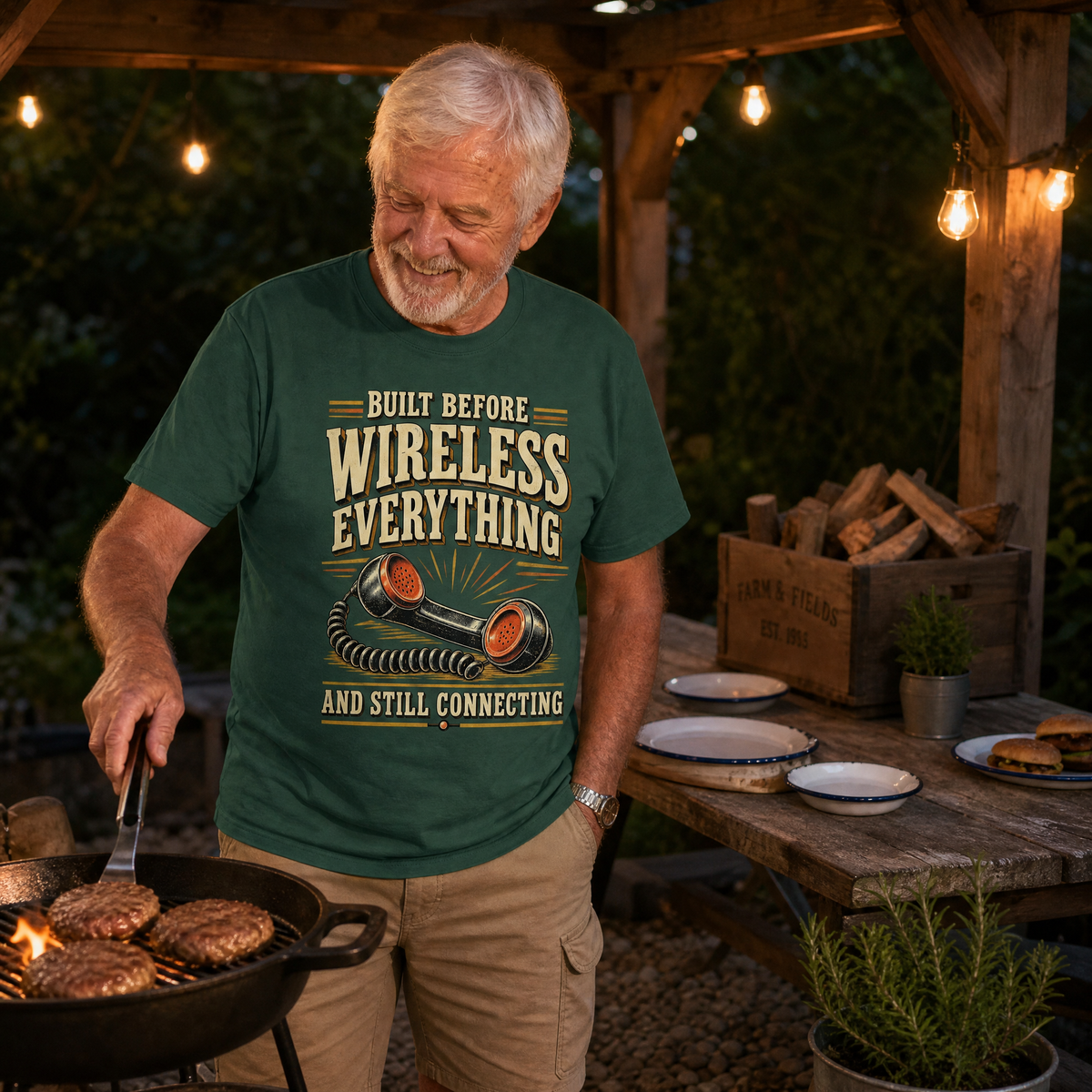 Green vintage t-shirt with printed “Built Before Wireless Everything” slogan, senior man grilling outdoors