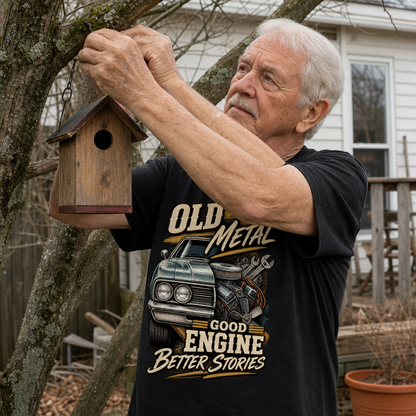 Senior man wearing black vintage t-shirt with printed Old Metal Good Engine Better Stories, hanging birdhouse outdoors