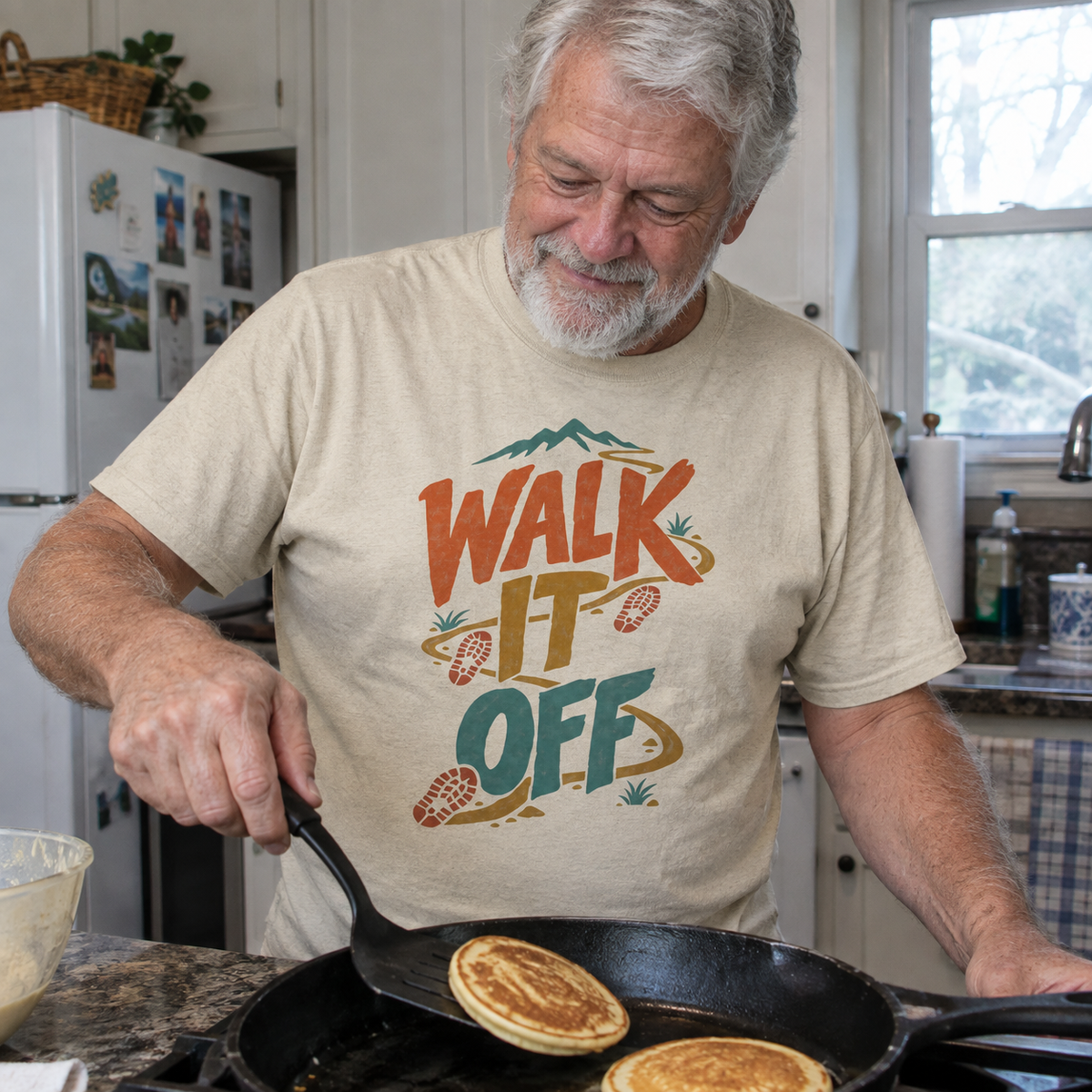 Beige vintage t-shirt with Walk It Off print worn by senior man cooking pancakes