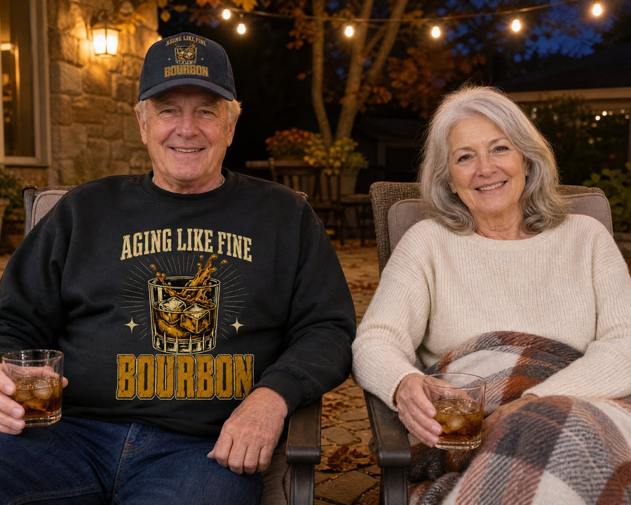 A couple on the patio on a cool evening, him in the black sweatshirt and navy cap, both with a glass