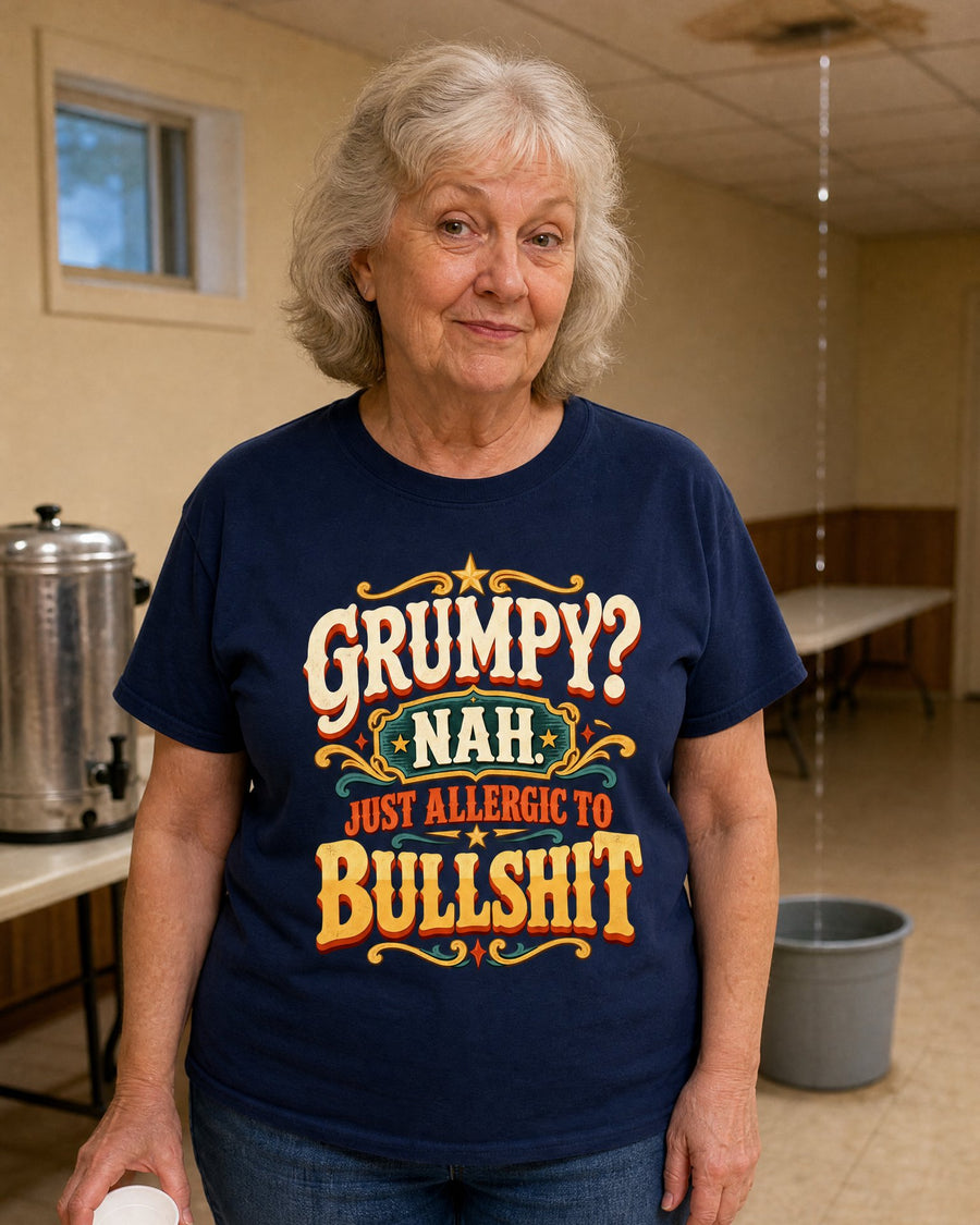 A grey-haired woman in the navy tee in a church basement, a bucket under a ceiling leak behind her