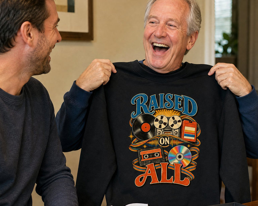 A father holding up the black sweatshirt his grown son just gave him